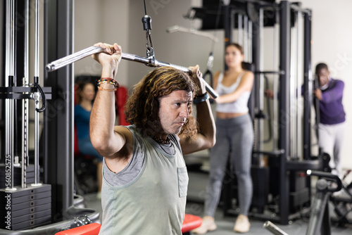 Caucasian man is engaged in a simulator for the development of back muscles