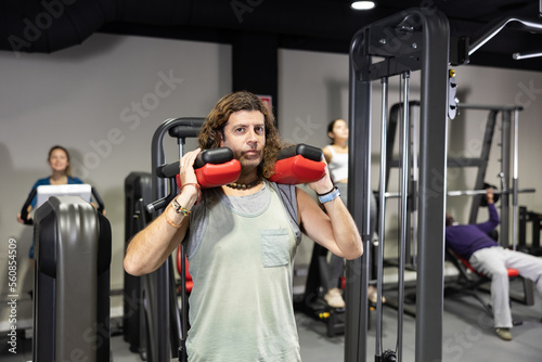 Caucasian man training on calf raise machine in gym © JackF