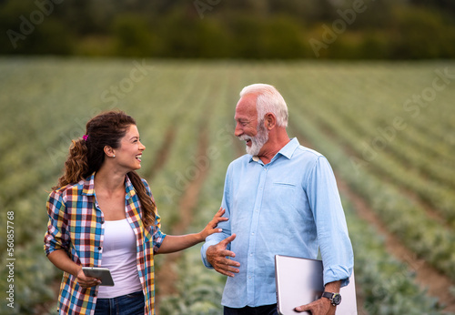 Farmer woman and senior businessman talking in cabbage field