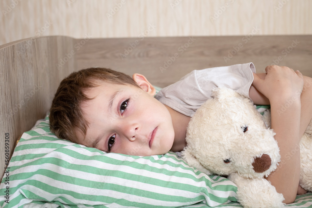 Unhealthy little boy child sleep in bed relax at home in bedroom. Sick ill little kid suffer from flu fever asleep in bed on lockdown quarantine Unhealthy little boy child sleep in bed relax at home in bedroom. Sick ill little kid suffer from flu fever asleep in bed on lockdown quarantine