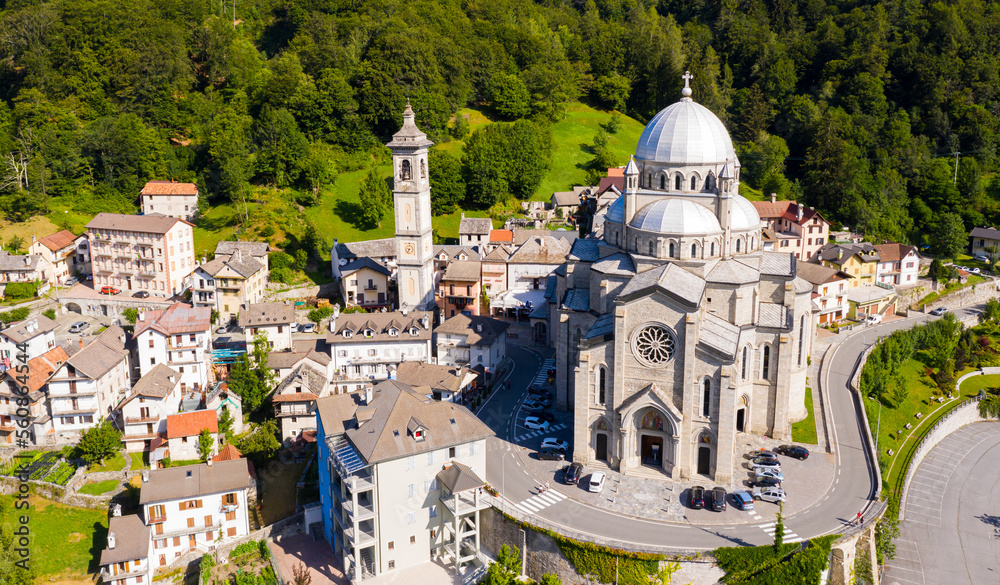 Picturesque summer view from drone of alpine township of Re with pilgrimage church of Virgin Mary surrounded by green Alps, Piedmont, Italy