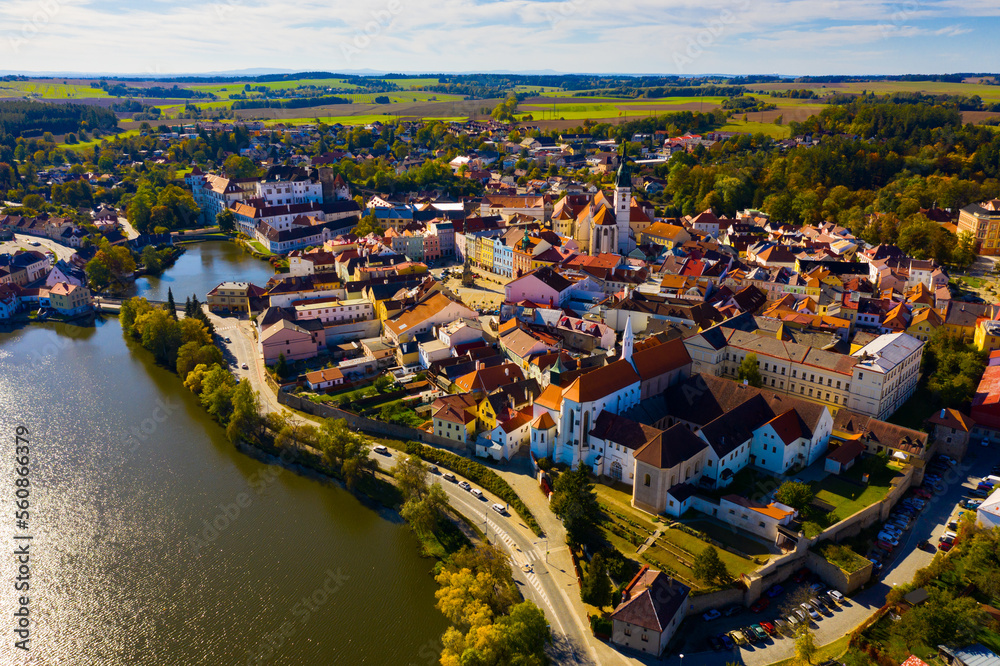 Autumn landscape with of historical area of small Czech town of Jindrichuv Hradec on banks of Nezarka river on sunny day