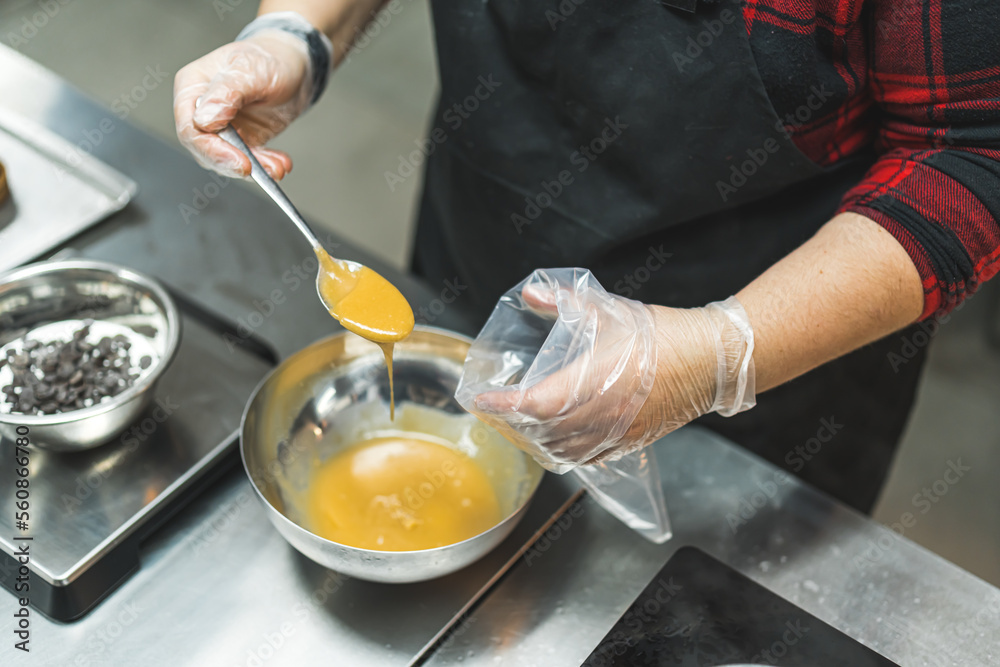 top view of chef's hands putting caramel from a bowl into a piping bag. High quality photo