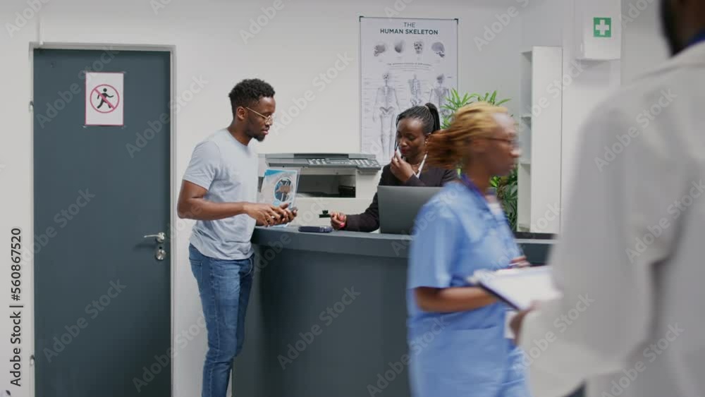 Male patient using mobile phone to pay with nfc on pos terminal, making transaction for medicine or treatment. Person using contactless payment after having checkup visit at health center.