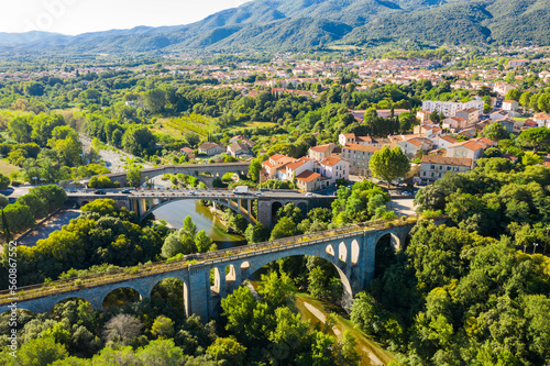 General view from drone of Ceret town on banks of river Tech in foothills of Pyrenees mountains in summer, France..