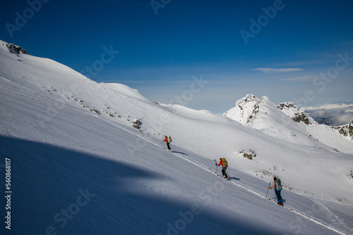 Skiers ascend a skin track at the top of a mountain in Whistler, British Columbia, Canada.