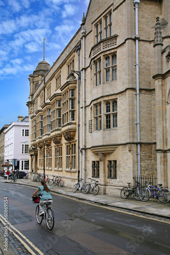 Street with Oxford University building and pub, and cyclist on the road