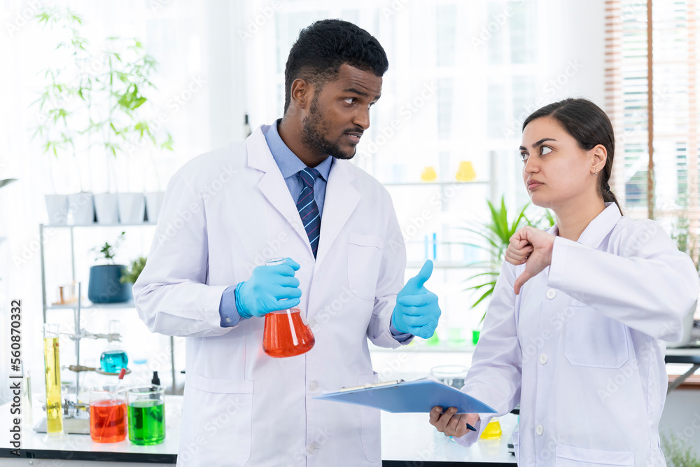 Two Young researcher analyzing liquid in tube at laboratory Two Young researcher analyzing liquid in tube at laboratory