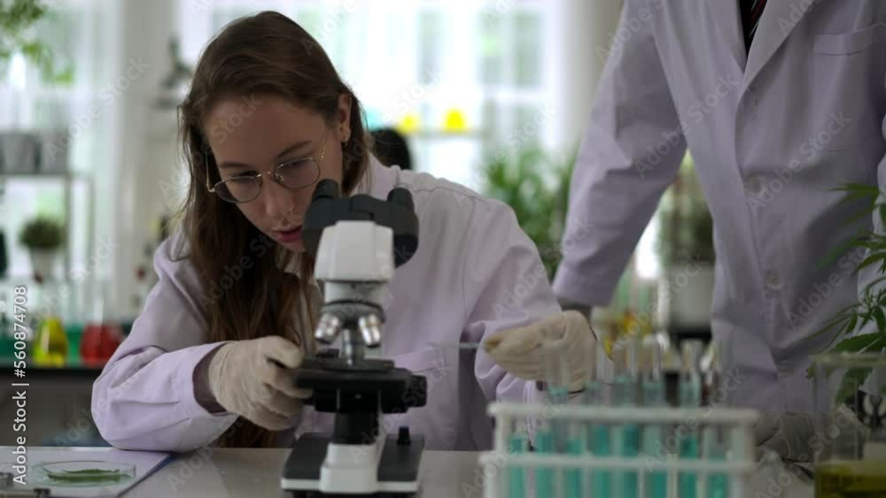 Young woman scientist working with microscope in Laboratory