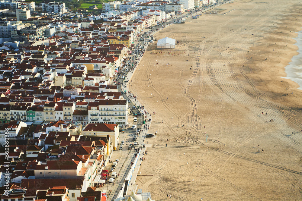 View Nazare beach riviera with cityscape of Nazare town at sunny weather. Portugal. High quality photo