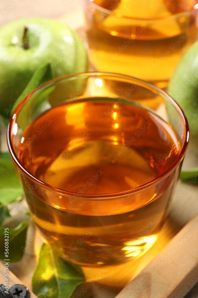 Glass of fresh apple juice on wooden tray, closeup Glass of fresh apple juice on wooden tray, closeup