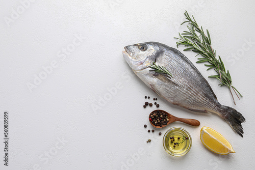 Flat lay composition with fresh raw dorado fish and ingredients on white table, space for text
