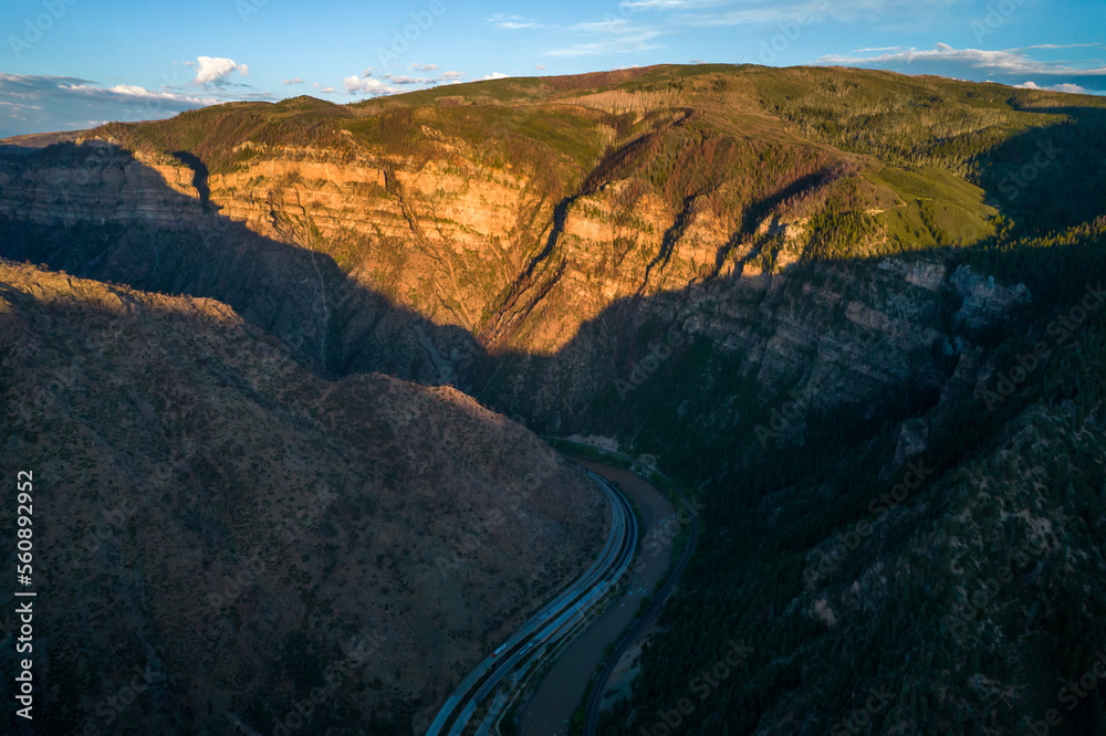 Aerial view of sunset in canyon with highway along small river.Landscape in the west.