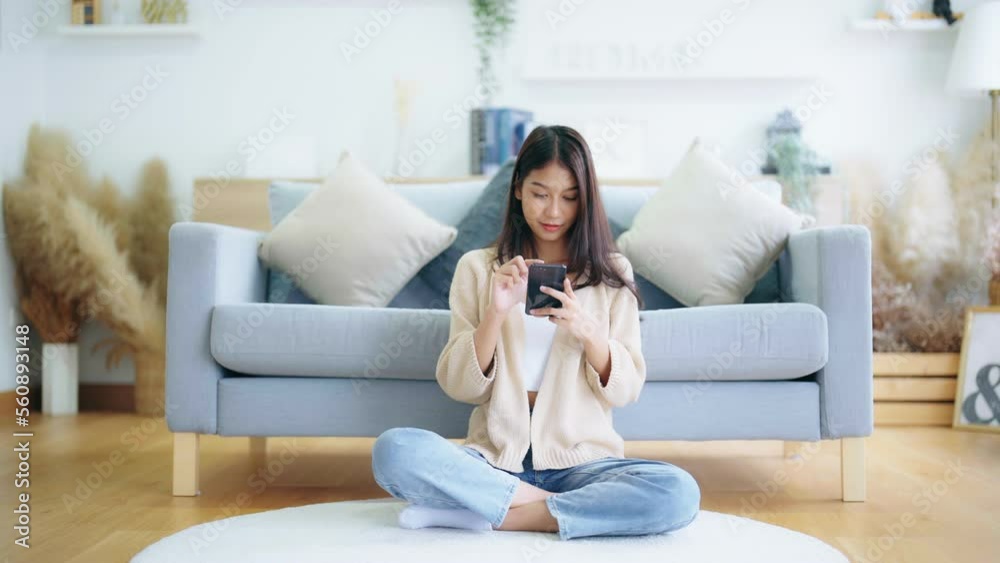 Happy young asian woman relax on comfortable couch at home texting messaging on smartphone, smiling girl use cellphone, chatting online message, shopping online from home Happy young asian woman relax on comfortable couch at home texting messaging on smartphone, smiling girl use cellphone, chatting online message, shopping online from home