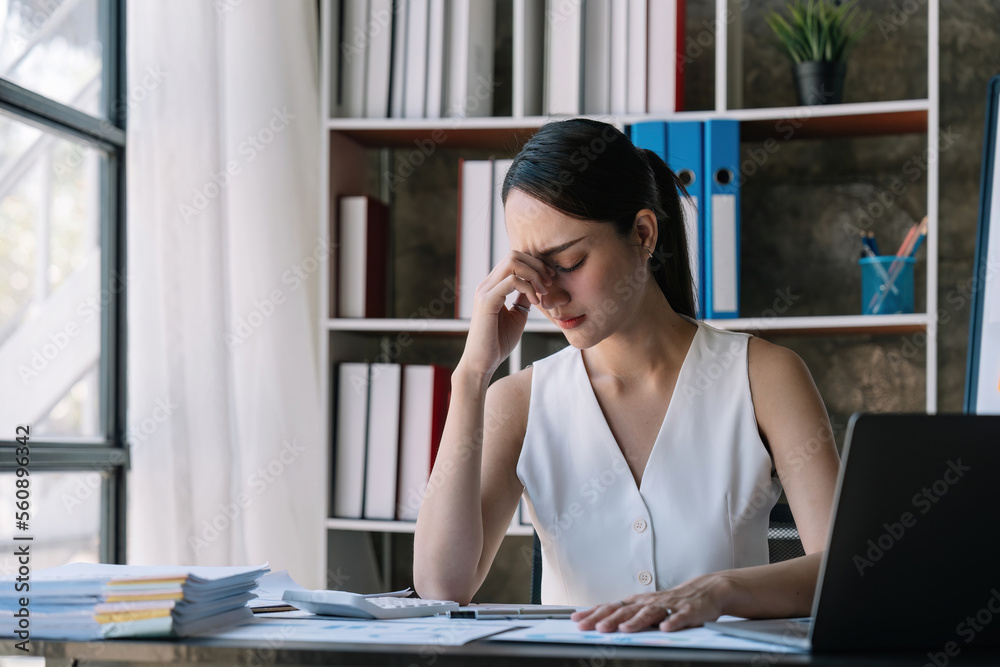 Asian woman stressed while working on laptop, Tired asian businesswoman with headache at office, feeling sick at work