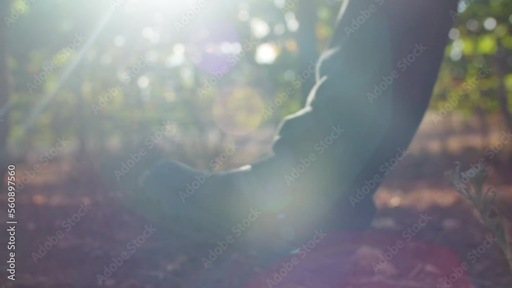 The shoes of a man walking on the soil of a vineyard in the morning. Handheld slow motion shot, low point-of-view.
