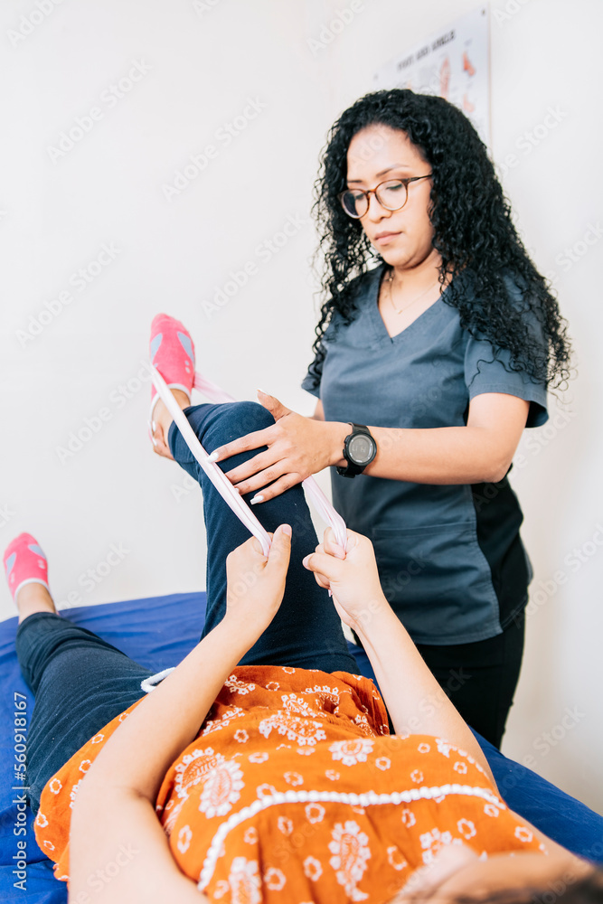Kinesiologist with patient knee with resistance band, Knee