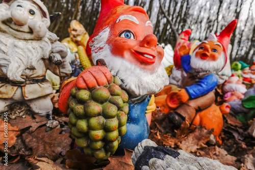 colorful garden gnomes with grapes at a place in the forest