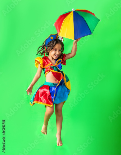 Brazilian child, girl, dressed in carnival outfit, dancing with frevo umbrella. Little girl, brazilian, with frevo clothes, carnival. dancing frevo.