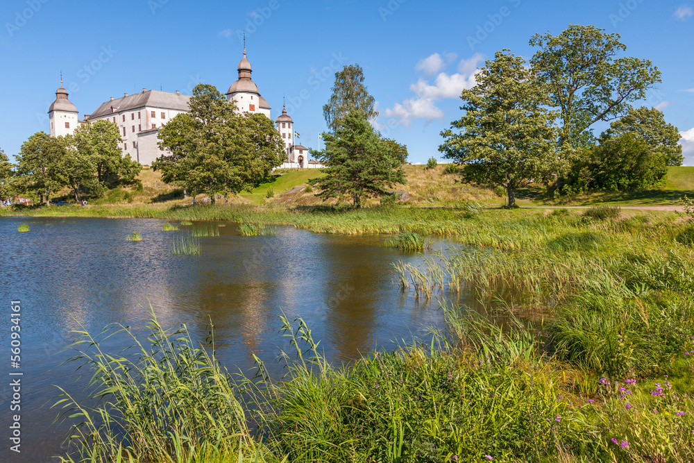 Lakeshore in the summer with a beautiful white Lacko castle in sweden Lakeshore in the summer with a beautiful white Lacko castle in sweden