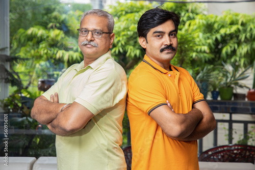 Portrait of indian senior father and son standing together looking at camera.