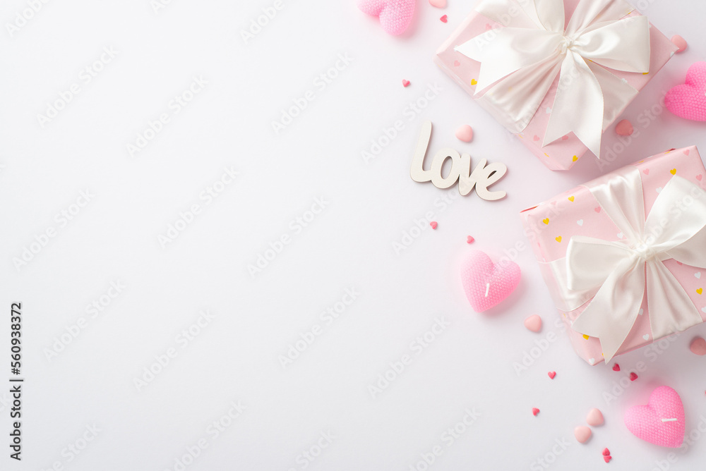 Valentine's Day concept. Top view photo of pastel pink gift boxes with silk ribbon bows heart shaped candles sprinkles and inscription love on isolated white background with blank space Valentine's Day concept. Top view photo of pastel pink gift boxes with silk ribbon bows heart shaped candles sprinkles and inscription love on isolated white background with blank space