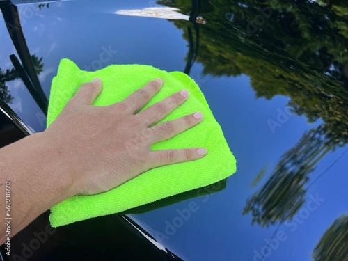 Close up man use soft towel to clean black car