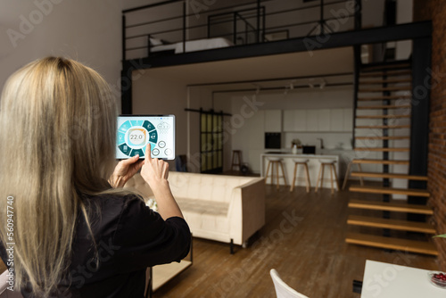 Smart home control on tablet. Interior of living room in the background