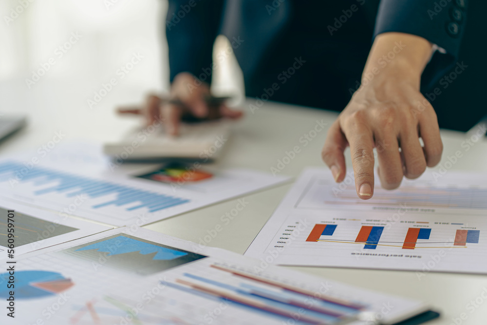 Hand of a business man using a calculator to check financial accounts, check expenditures and company budget. Female accountant calculating while working analyzing business reports at work