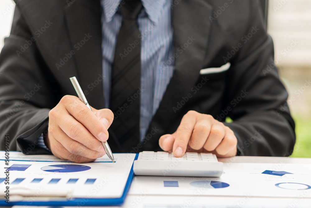 Hand of a business man using a calculator to check financial accounts, check expenditures and company budget. Female accountant calculating while working analyzing business reports at work Hand of a business man using a calculator to check financial accounts, check expenditures and company budget. Female accountant calculating while working analyzing business reports at work