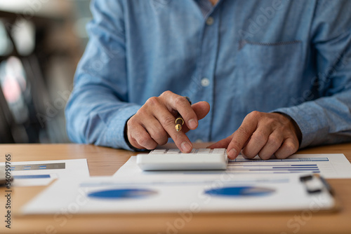 Wallpaper Mural Hand of a business man using a calculator to check financial accounts, check expenditures and company budget. Female accountant calculating while working analyzing business reports at work Torontodigital.ca