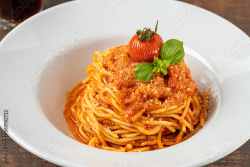 Pasta with cheese and tomato sauce on a white porcelain plate