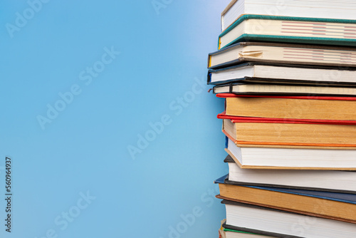 Stack of books in the colored cover lay on blue backround. Education learning concept