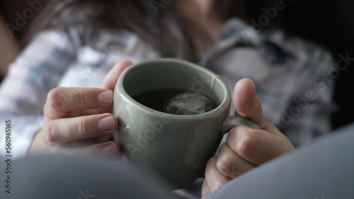 Woman holding cup of tea mug. Female hand closeup holds hot beverage