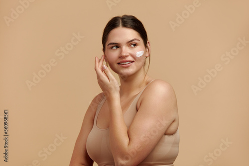 Positive Woman Applying Face Cream. Closeup Of Female Model With Fresh Skin Applying Cosmetic Product Under Eyes. Skincare Concept. High Resolution 