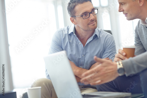 Business man, laptop and team in discussion for deal, proposal or corporate idea at office. Business people talking, strategy or planning market strategy or advertising in conversation at workplace