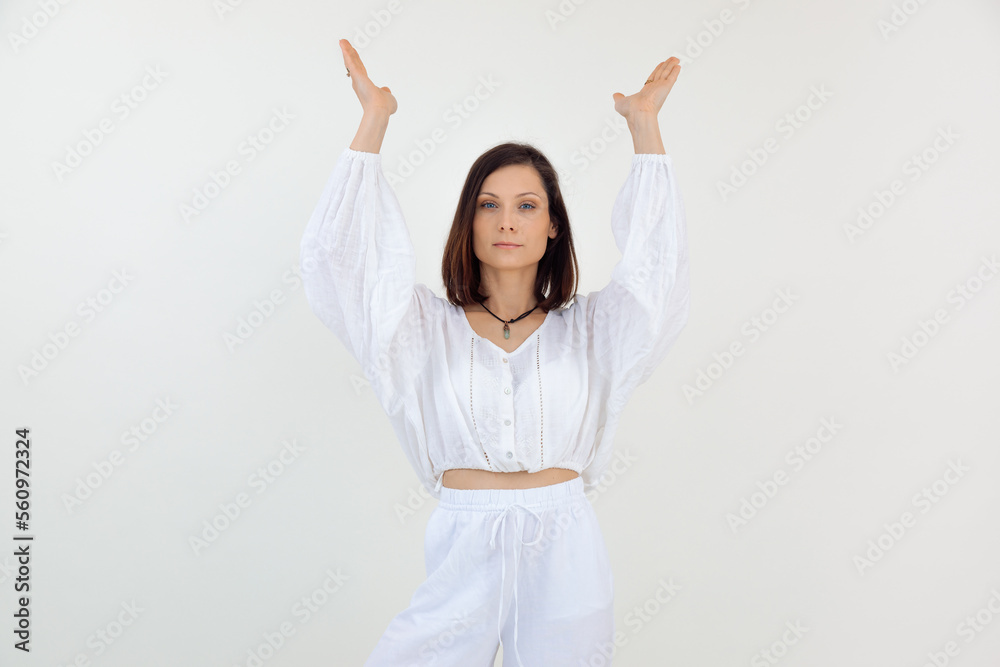 Portrait of young woman standing, raising hands, praying, showing, looking at camera on white background. Advertisement. Portrait of young woman standing, raising hands, praying, showing, looking at camera on white background. Advertisement.
