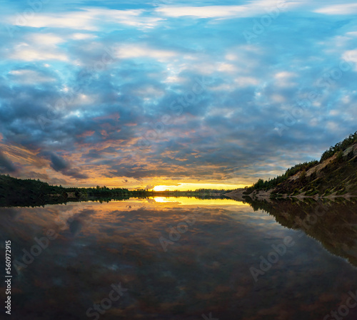 The dark sky with gaps at sunset is reflected in the lake .