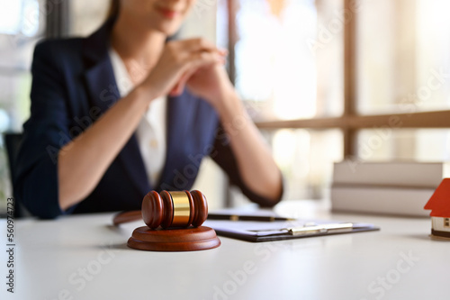 Judge gavel is on the table over blurred background of a professional female lawyer.