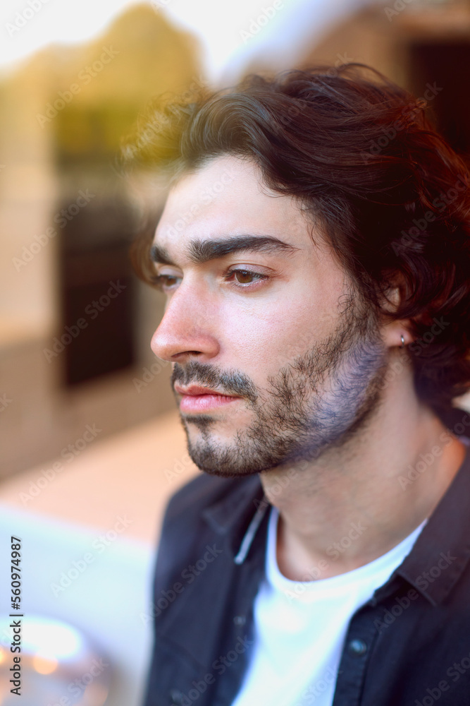 Obraz premium Thoughtful Young Man At Home In Kitchen Looking Out Through Window