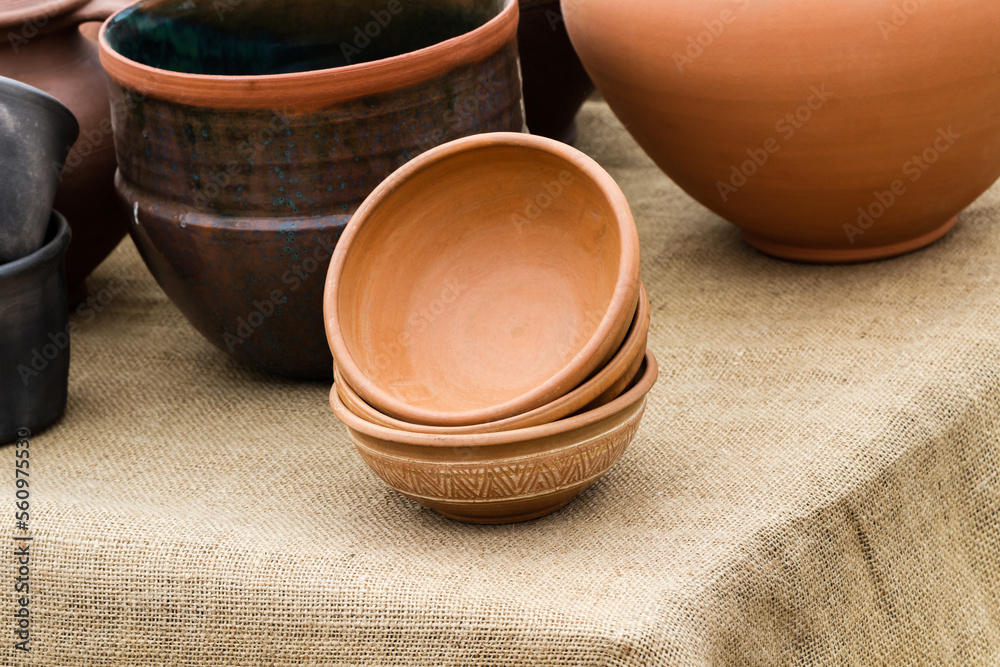 Many clay pots on wooden table for sale on fair Many clay pots on wooden table for sale on fair