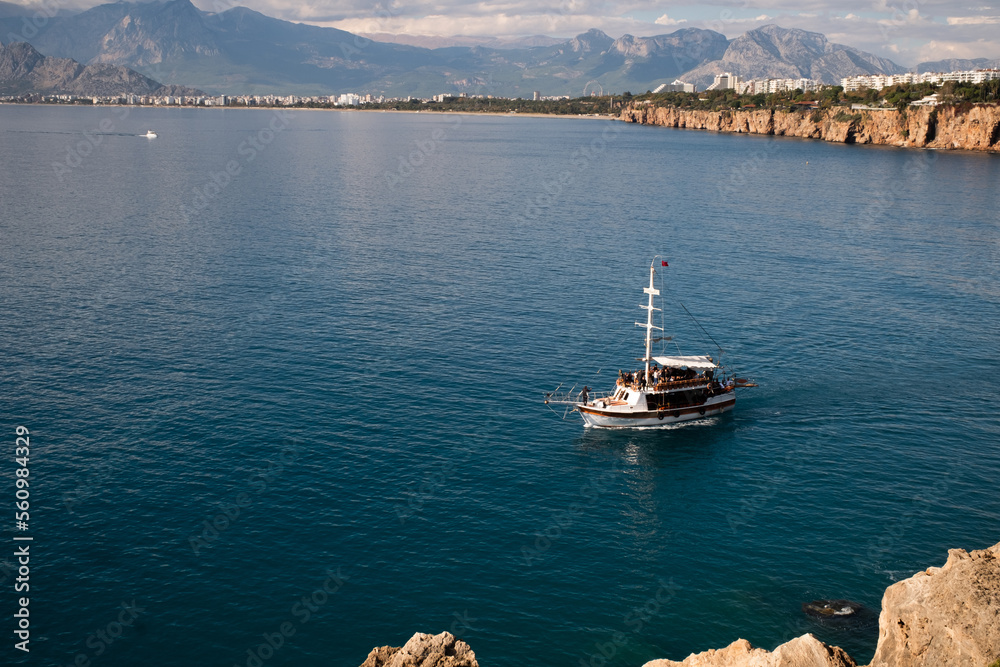 motor ship in the daylight sunlight over beautiful big mountains background, luxury summer adventure, active vacation in Mediterranean Sea, Antalya, Turkey