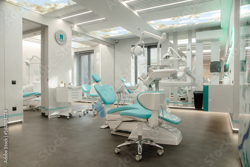 Dentist s chair in modern well lit ambient. No people  just the office. Desaturated photo for more business like feel.