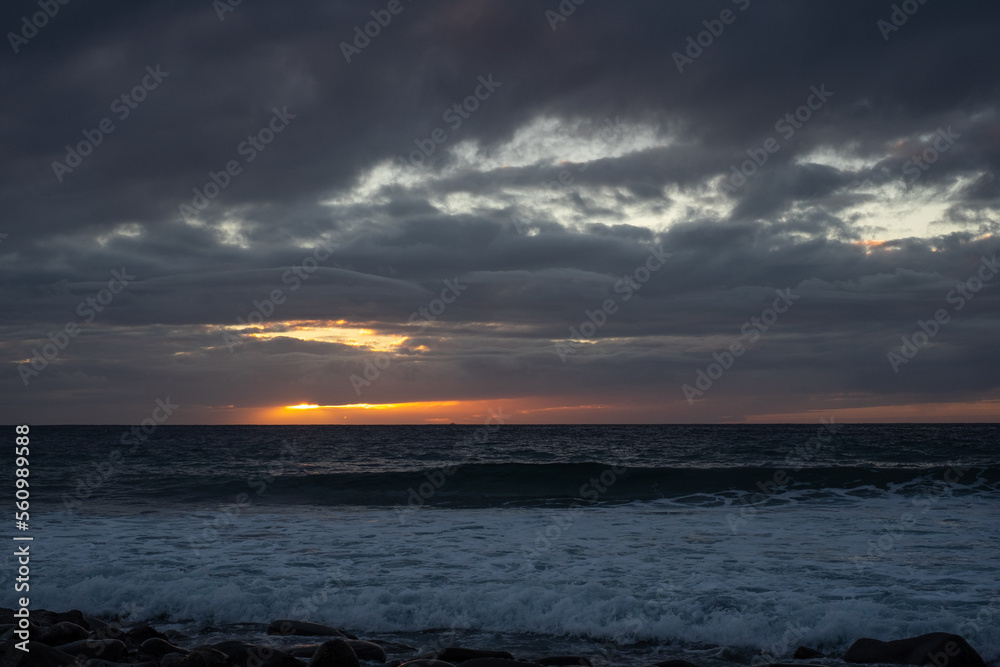 Dramatic sky and orange sunset from the beach - atlantic ocean in Tenerife, canary islands. Travel and vacation concept Dramatic sky and orange sunset from the beach - atlantic ocean in Tenerife, canary islands. Travel and vacation concept