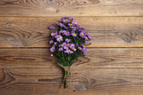 Bouquet of small purple asters on old wooden boards.