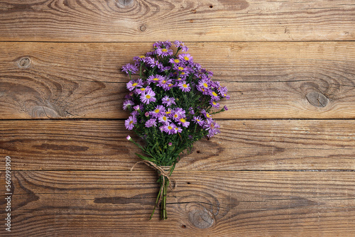 Bouquet of small purple asters on old wooden boards.