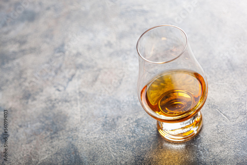 glass of whisky spirit brandy on grey concrete background © Olga Miltsova