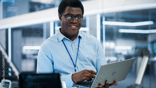 Portrait of a Handsome African Man Wearing Smart Corporate Wear and Glasses, Looking at Camera and Smiling. Businessman, Information Technology Manager, Developer, Robotics Engineering Specialist.