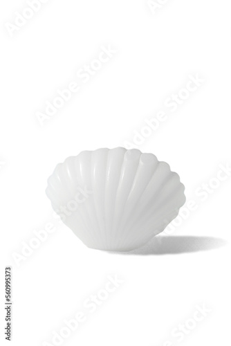 Subject shot of a figured white candle in the shape of a sea shell. The designer handmade shell candle is isolated on the white background.