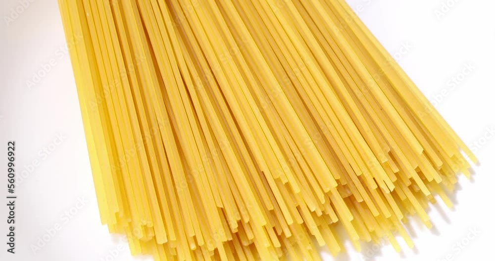 Uncooked pasta on white plate close-up. Dry spaghetti macro shot. Macaroni in bright sunlight. Uncooked pasta on white plate close-up. Dry spaghetti macro shot. Macaroni in bright sunlight.